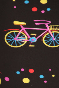Lovely pink bicycles with various colored polka dots grace this black background.
