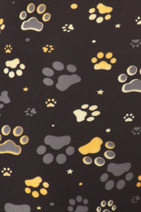 Close up of the Capri pattern with multi colored paw prints in shades of yellow, gold, white, tan and gray. Some of the paw prints are outlined in a different stated color.